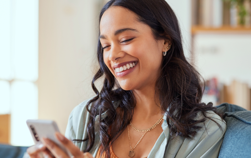 person smiling and looking at their phone