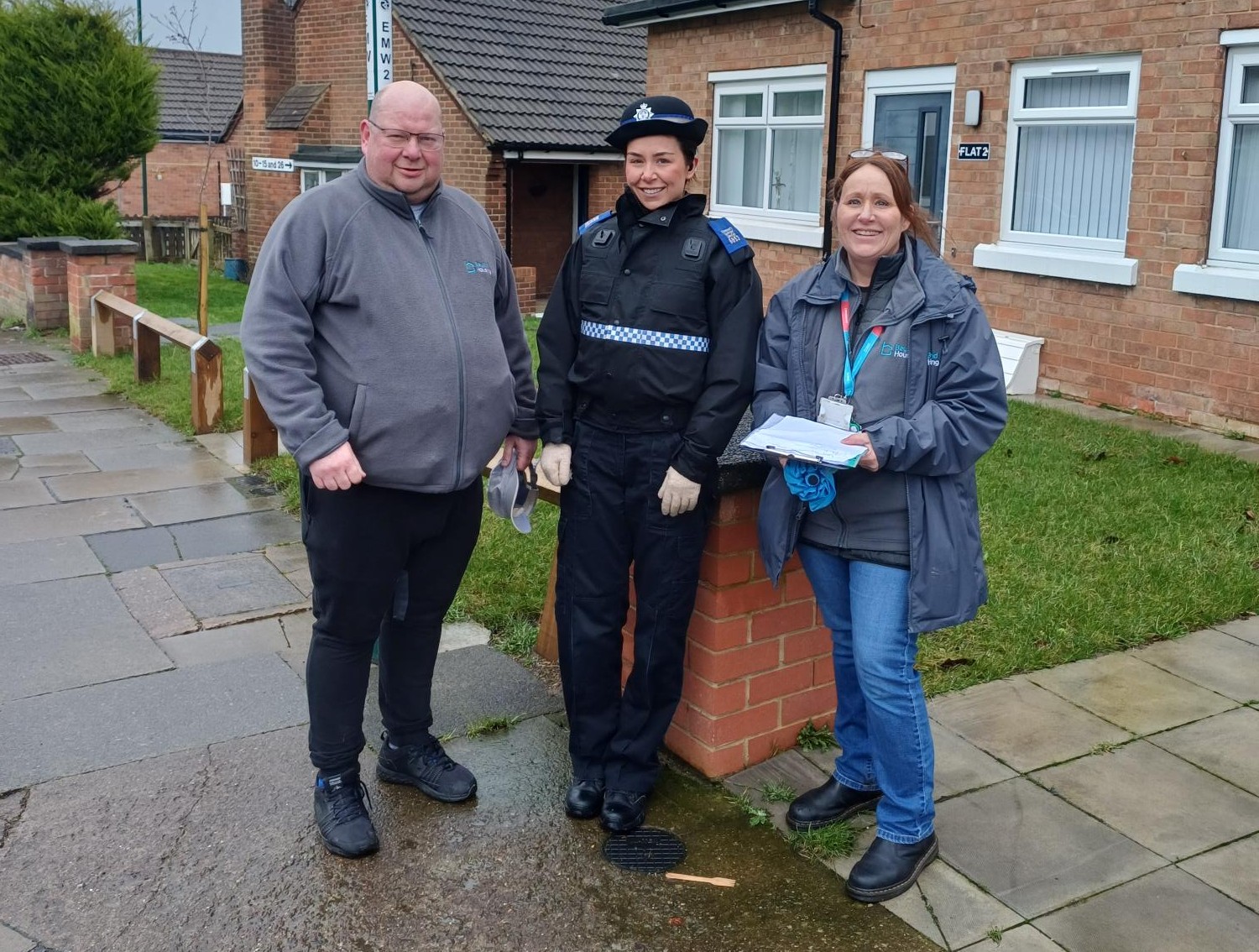 Three people stood outside a house