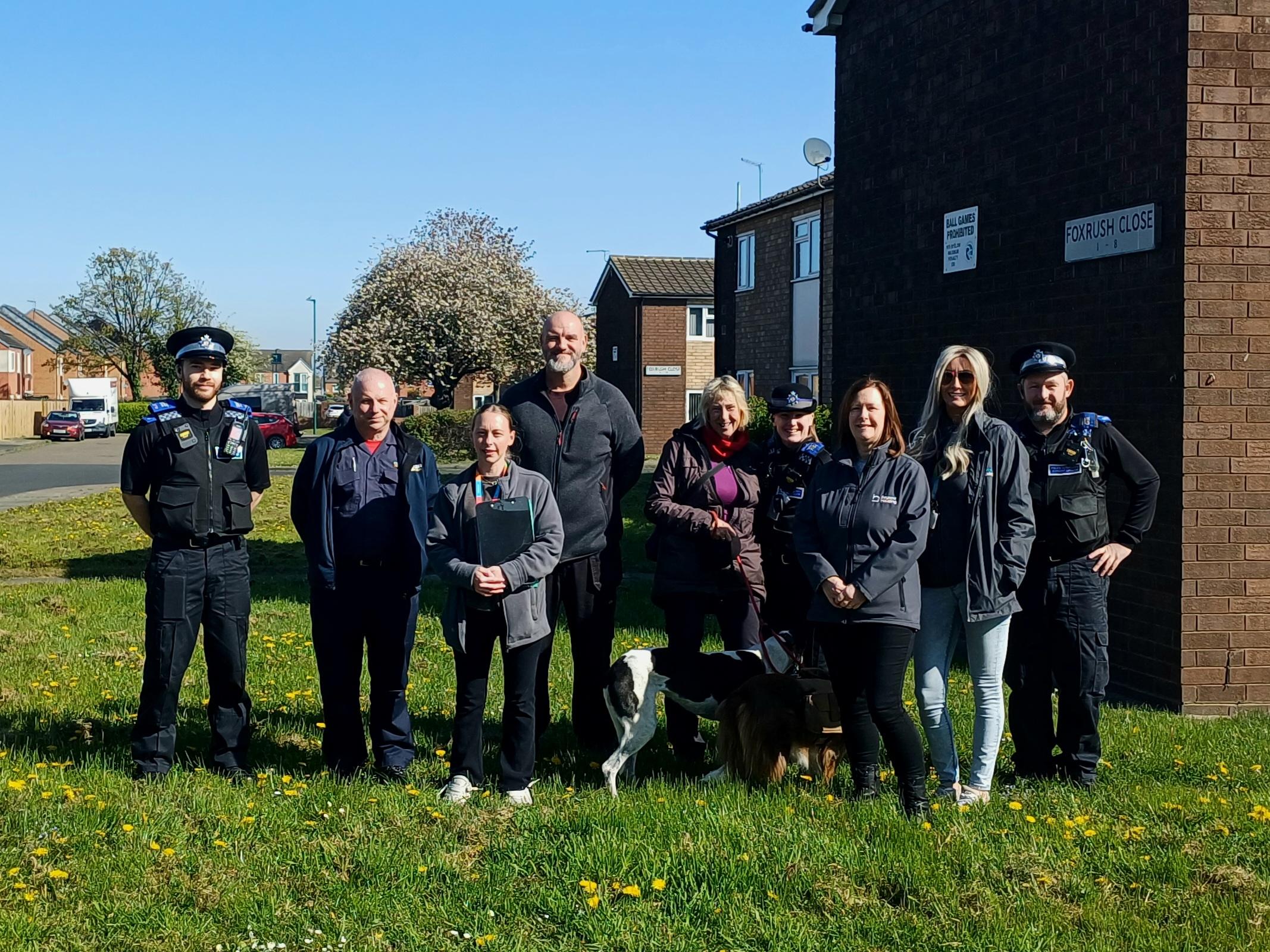 Nine people, and two dogs, stood on a street